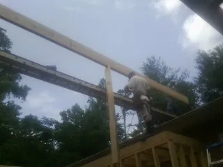Carpenter setting a ridge beam over a new addition frame — Ice Dam Removal by Roofing Brothers in Pawhuska
