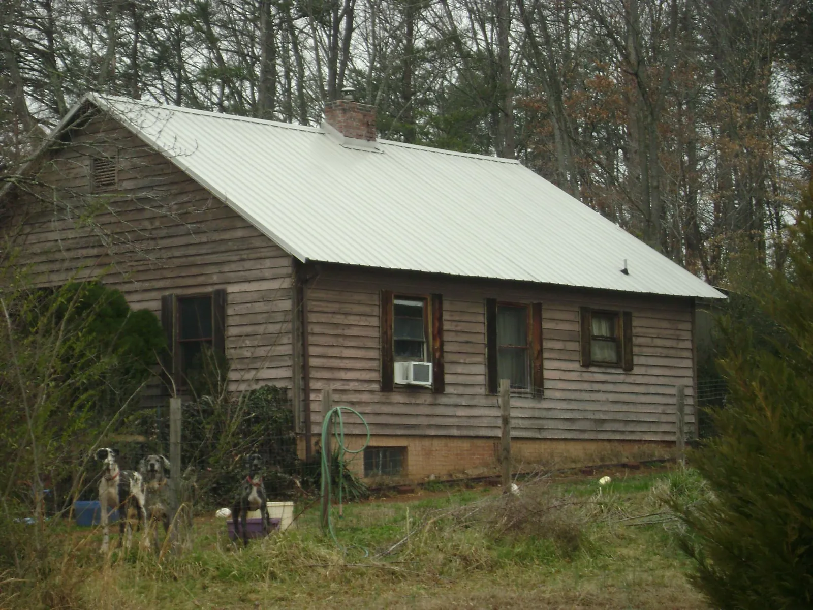 White metal roof on an old wood sided farmhouse, from a Metal Roof Installation job in Pawhuska